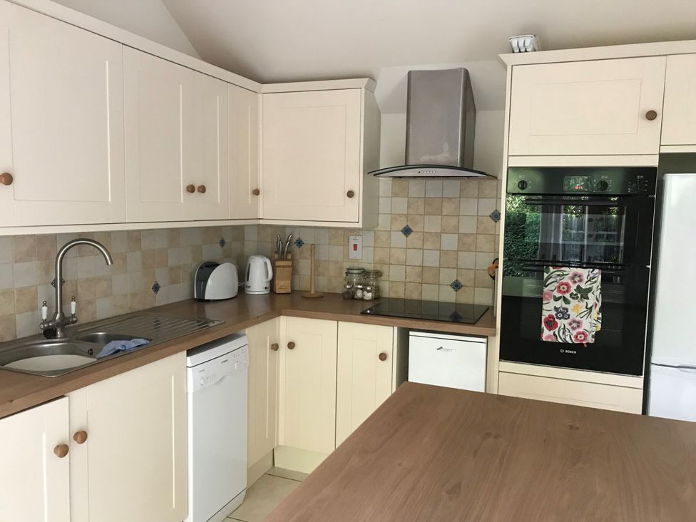 A kitchen with cabinets and appliances at Meadow Lodge in Cerney Wick near South Cerney, Cotswolds