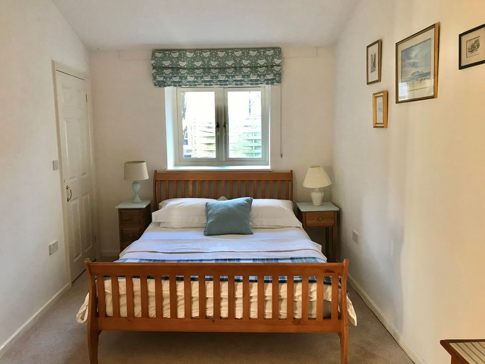 A bedroom with a bed and bedside tables at Meadow Lodge, Cerney Wick near South Cerney, Cotswolds