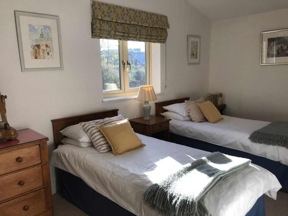 A bedroom with two beds and a lamp at Meadow Lodge, Cerney Wick near South Cerney, Cotswolds
