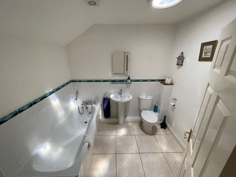 A bathroom with a bathtub, toilet, and sink at Meadow Lodge, Cerney Wick near South Cerney, Cotswolds