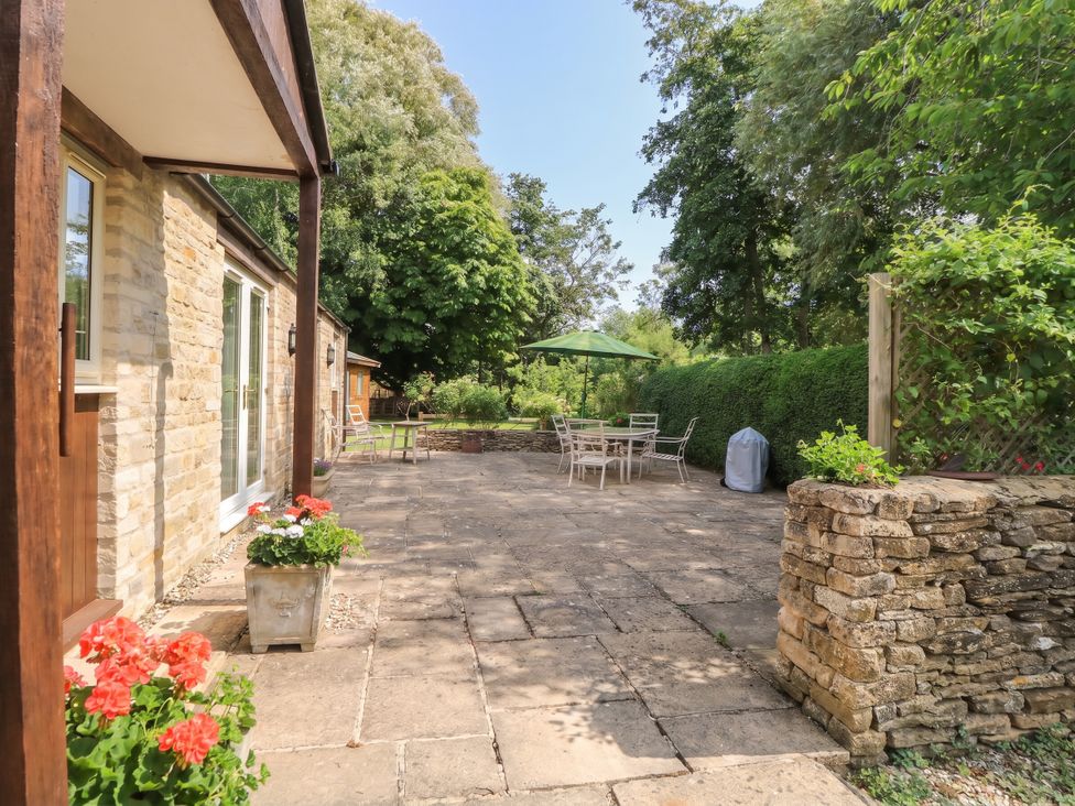 A patio area with a table and chairs at Meadow Lodge in Cerney Wick near South Cerney, Cotswolds
