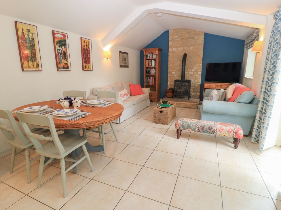 A living room with a dining area and a sofa at Meadow Lodge in Cerney Wick near South Cerney, Cotswolds