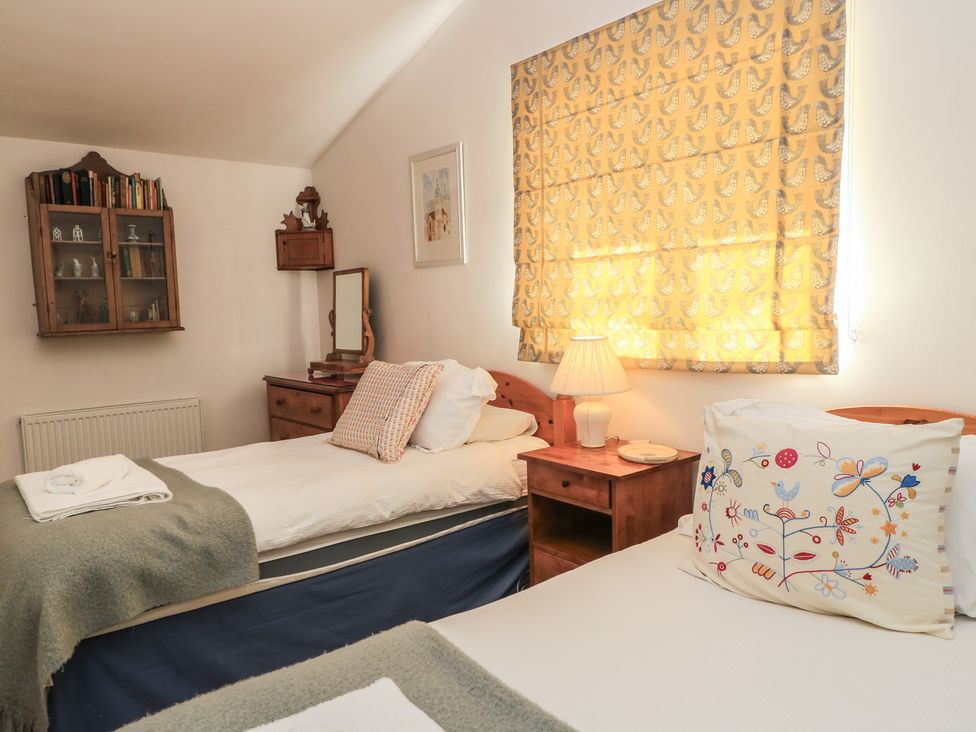 A bedroom with two beds and a lamp at Meadow Lodge, Cerney Wick near South Cerney, Cotswolds