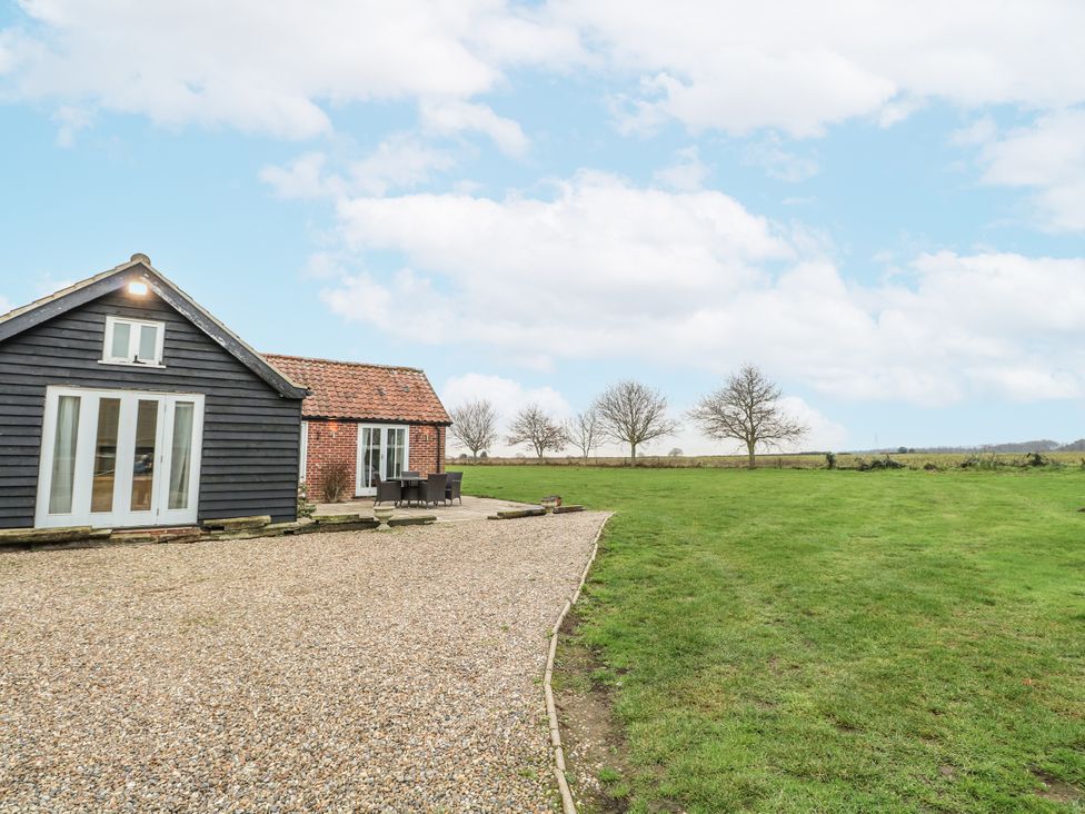 A house with a gravel pathway and outdoor furniture at Ivy Barn Norwich