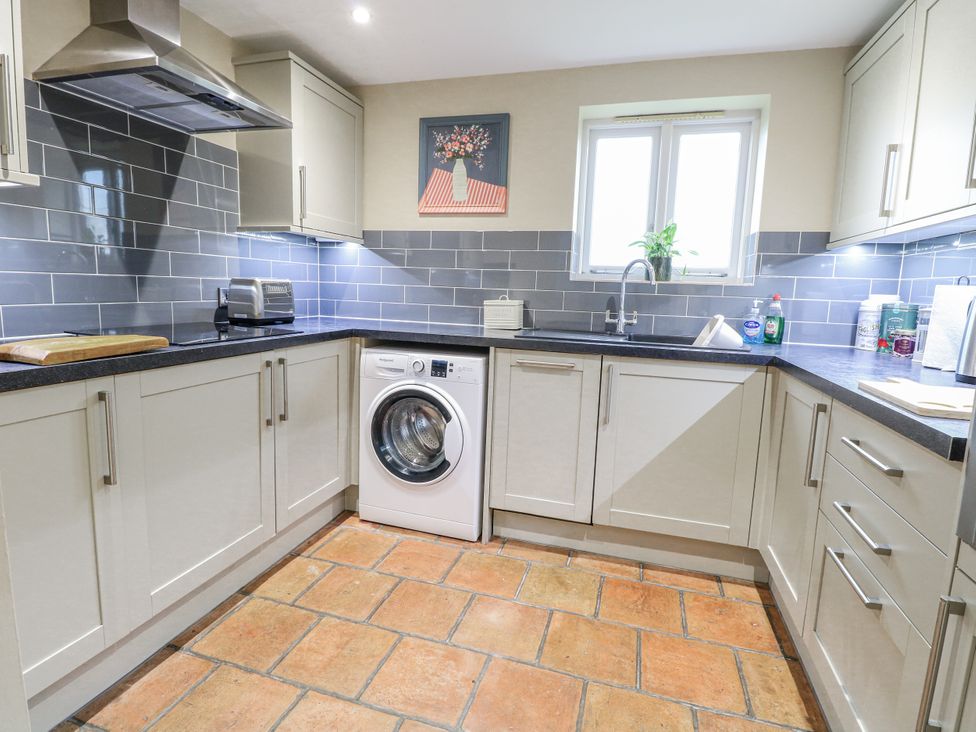 A kitchen with a washing machine and sink at Ivy Barn in Norwich