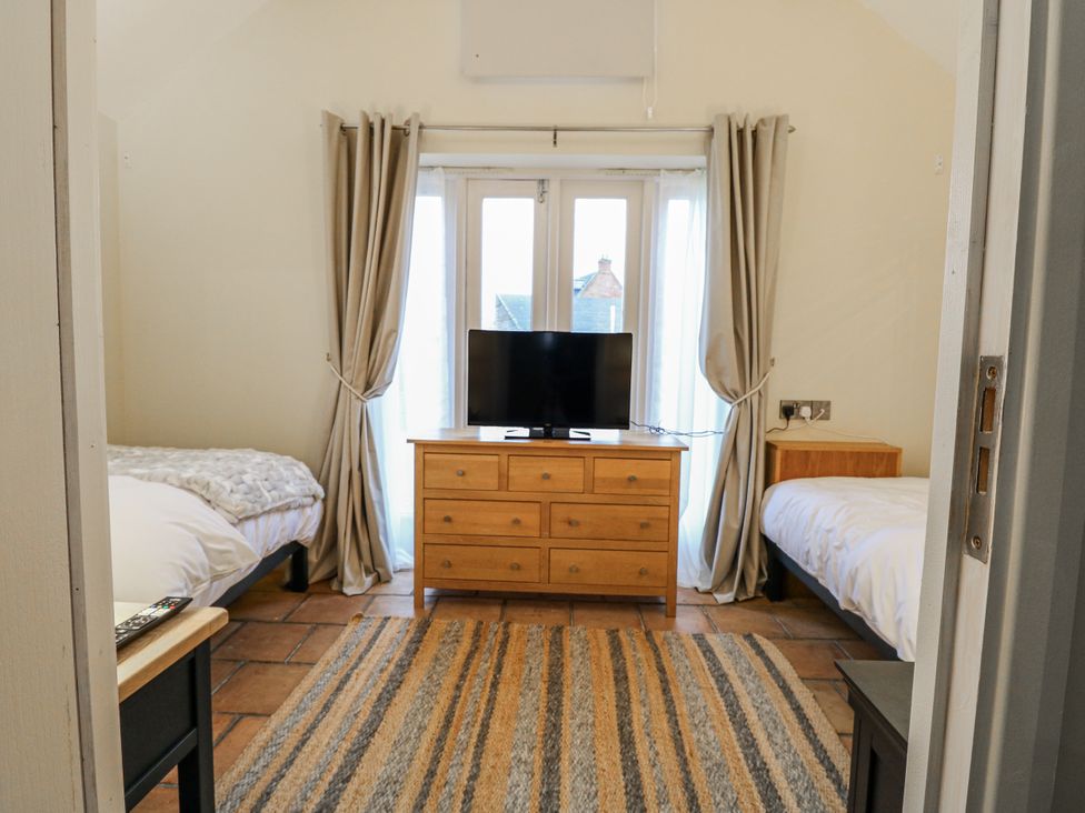 A bedroom with two beds and a television at Ivy Barn in Norwich