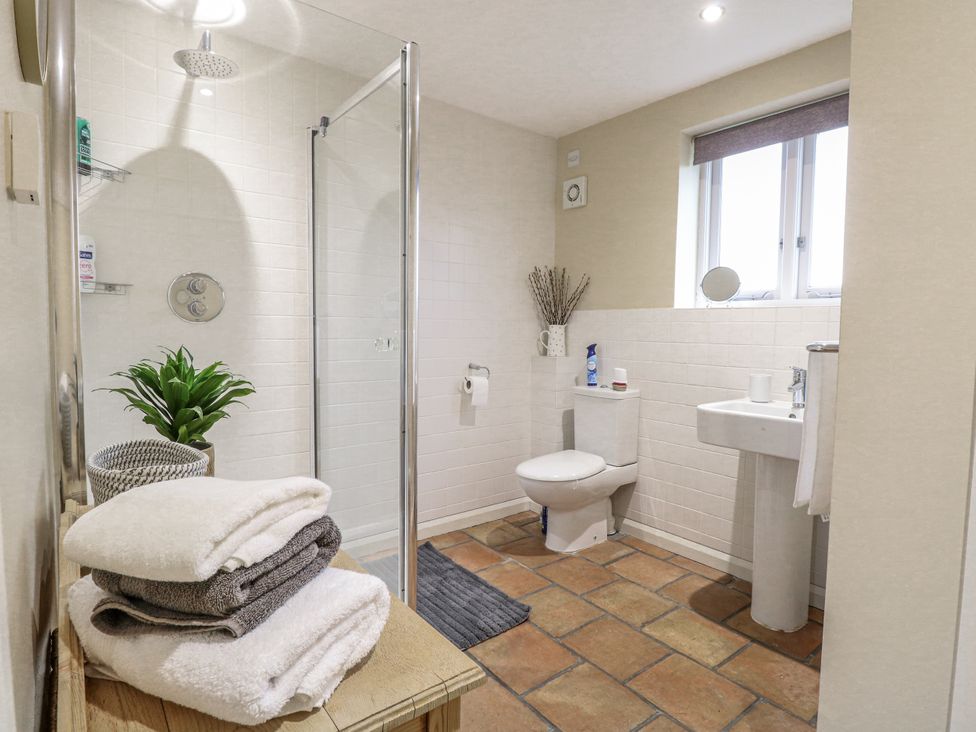 A bathroom with a shower, toilet, and sink at Ivy Barn in Norwich