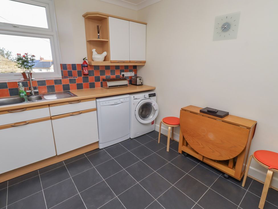 A kitchen with appliances and furniture at Kittiwake at No 20 Seahouses