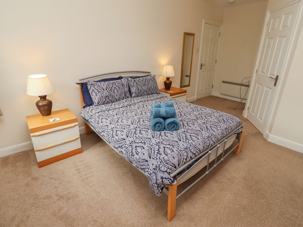 A bedroom with a bed and bedside table at Kittiwake at No 20 Seahouses