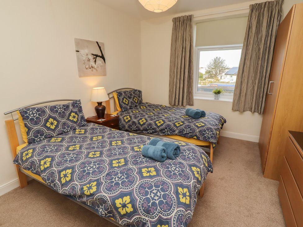 A bedroom with two beds and a lamp at Kittiwake at No 20 Seahouses