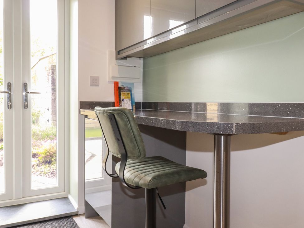 A kitchen with a bar stool and counter at The Annex At The Barn in Pelynt