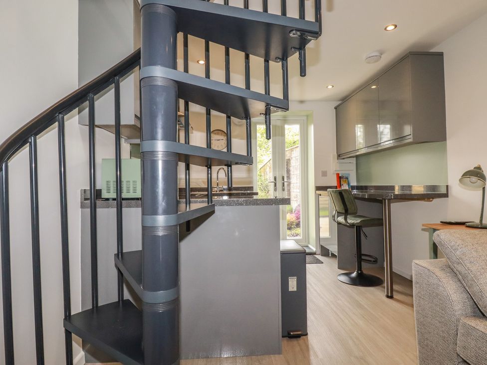 A kitchen with a spiral staircase and worktop at The Annex At The Barn in Pelynt