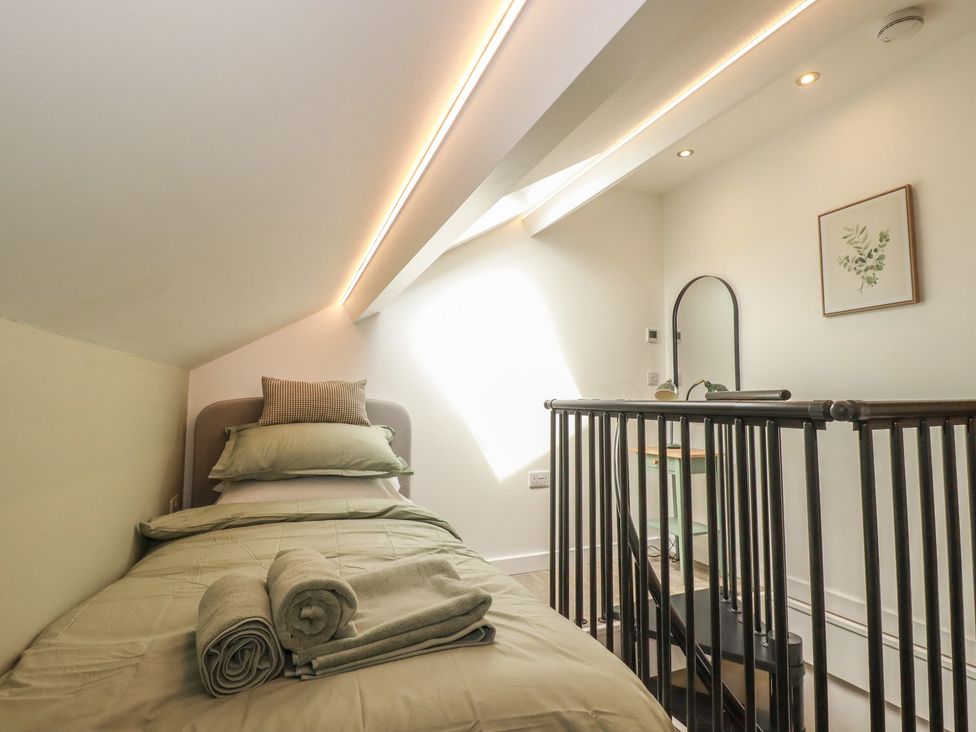 A bedroom with a bed and towels at The Annex At The Barn in Pelynt