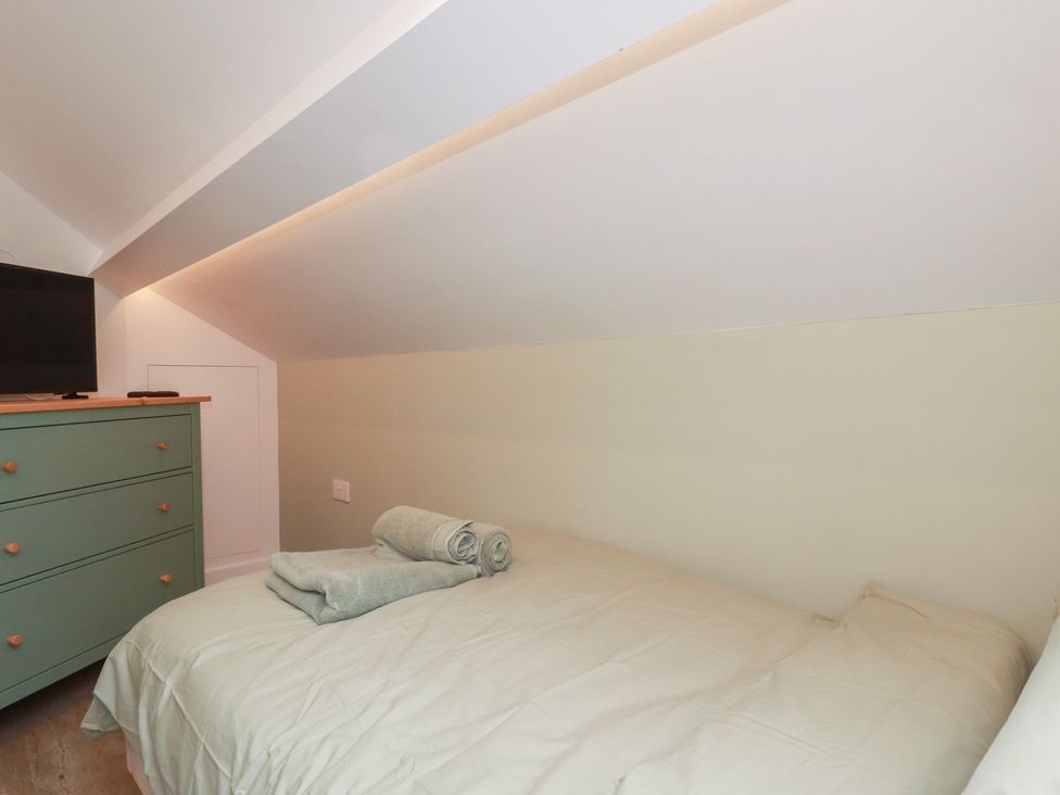 A bedroom with a bed and a television at The Annex At The Barn in Pelynt