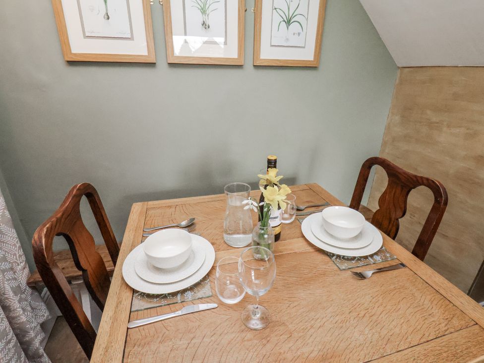 A dining room with a table set for two at Ingleside Cottage in Whitby