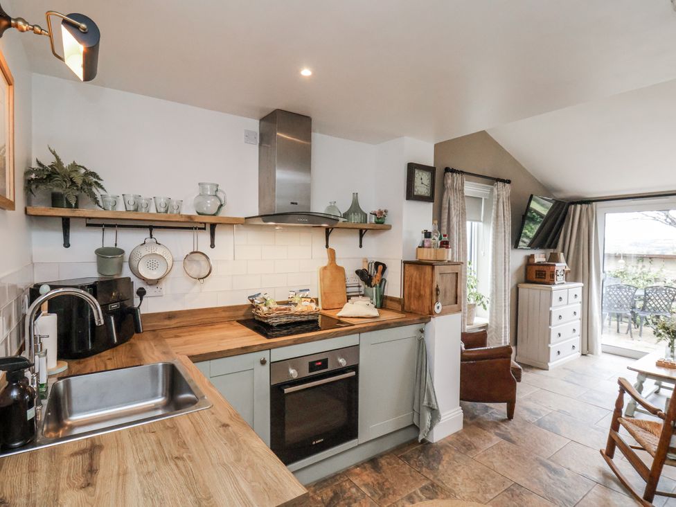 A kitchen with sink and stove at Ingleside Cottage in Whitby
