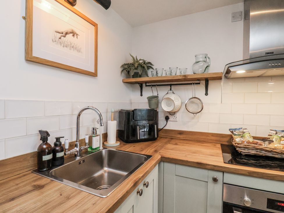 A kitchen with a sink, faucet and appliances at Ingleside Cottage in Whitby