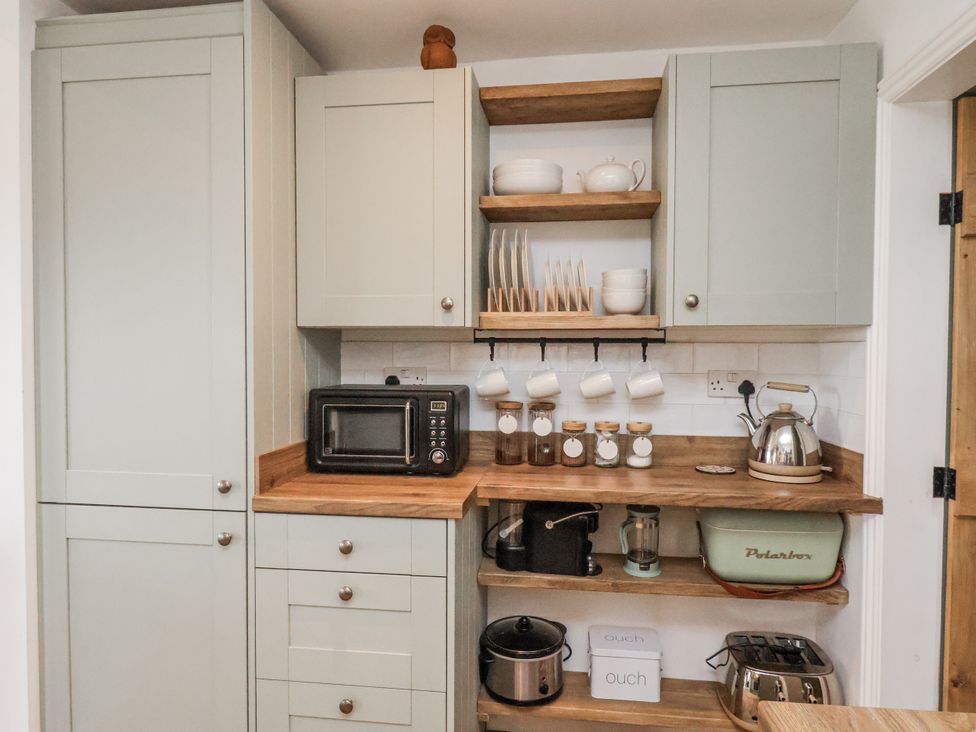 A kitchen with appliances and storage at Ingleside Cottage in Whitby