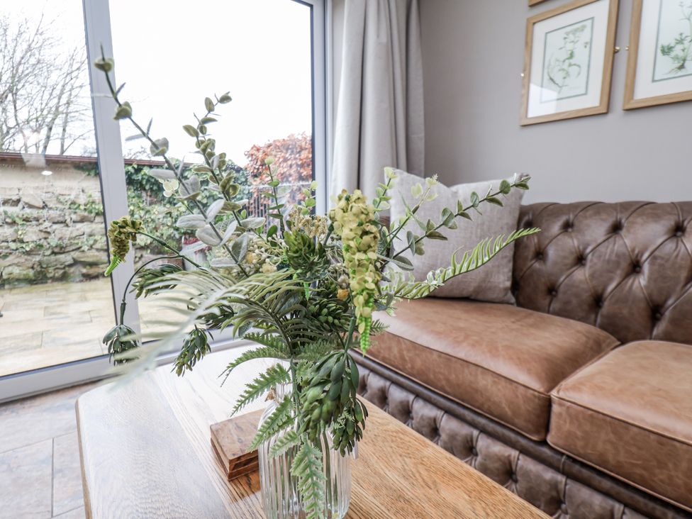 A living room with a plant in a vase on a table at Ingleside Cottage Whitby