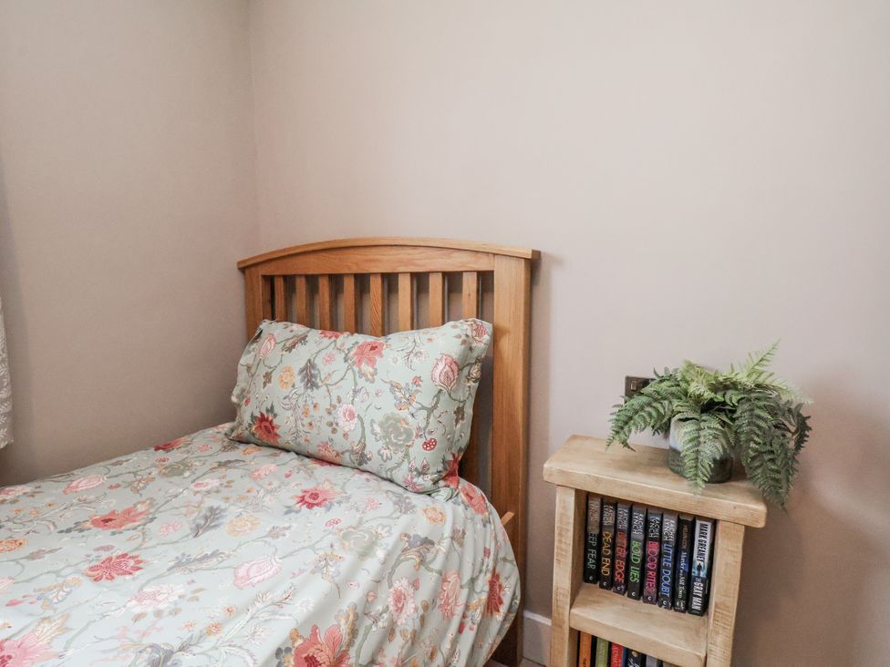 A bedroom with a bed and nightstand at Ingleside Cottage in Whitby