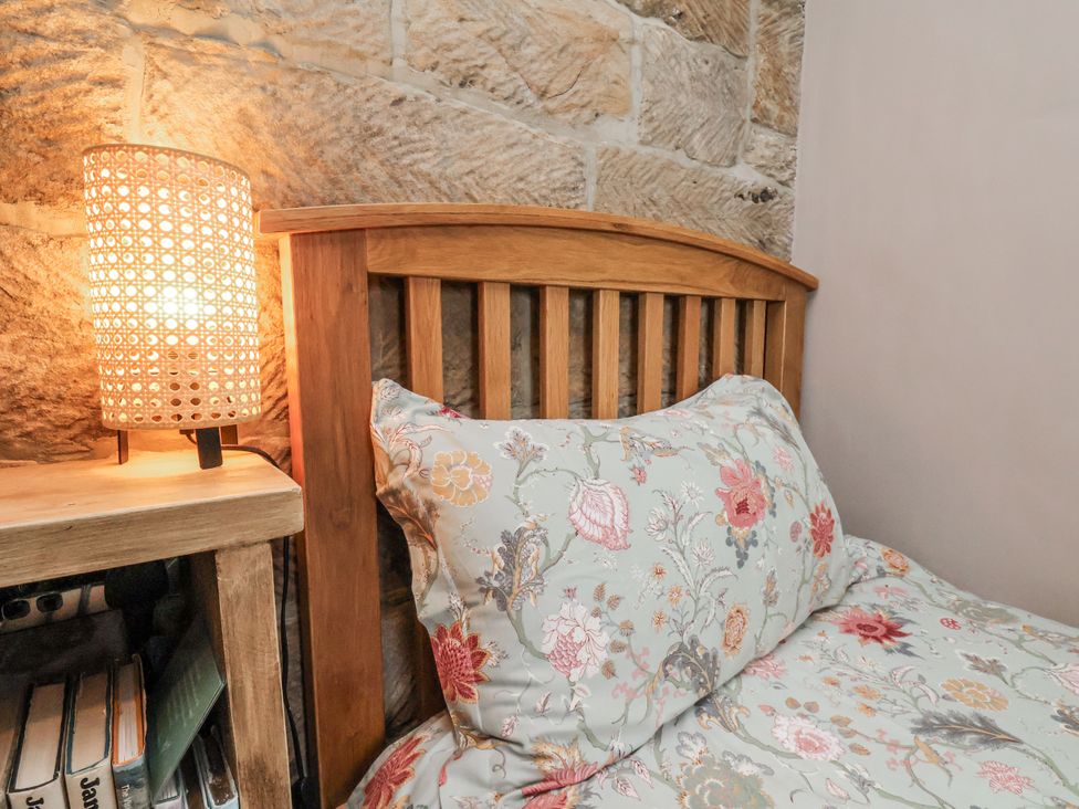 A bedroom with a bed and a lamp at Ingleside Cottage in Whitby