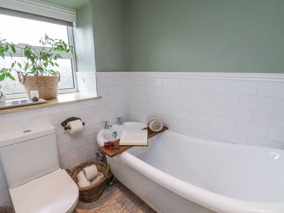 A bathroom with a bathtub and toilet at Ingleside Cottage in Whitby