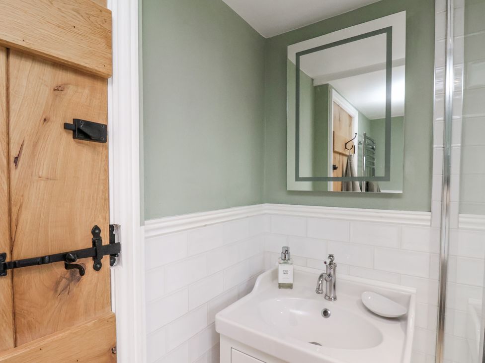 A bathroom with a sink and a mirror at Ingleside Cottage in Whitby