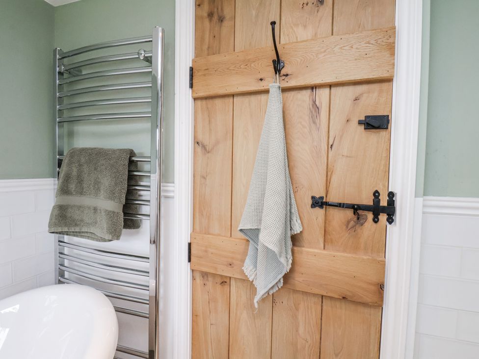 A bathroom with a towel rail and wooden door at Ingleside Cottage in Whitby