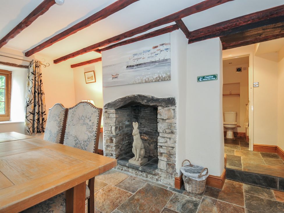 A dining room with a fireplace and bathroom access at Little Blagdon in Beaworthy