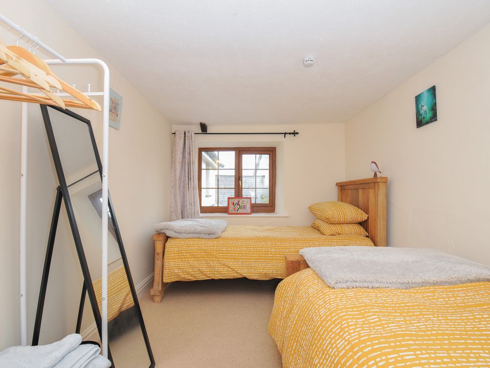 A bedroom with two beds and a window at Little Blagdon in Beaworthy