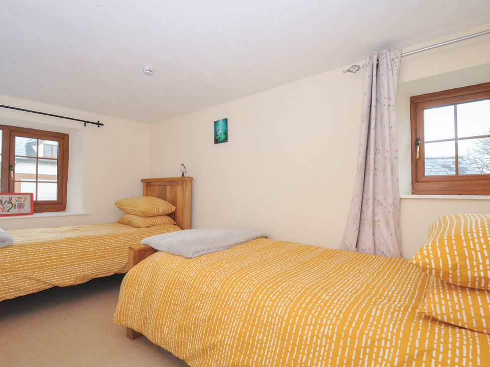 A bedroom with two beds and a window at Little Blagdon in Beaworthy