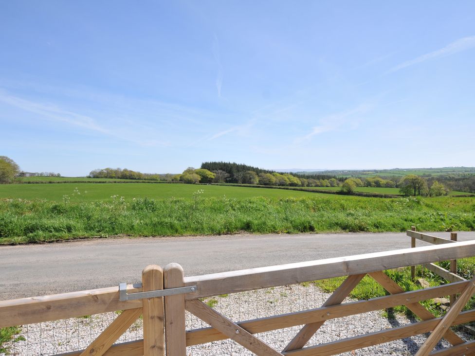 A view of fields and hills beyond a wooden gate at Little Blagdon in Ashwater