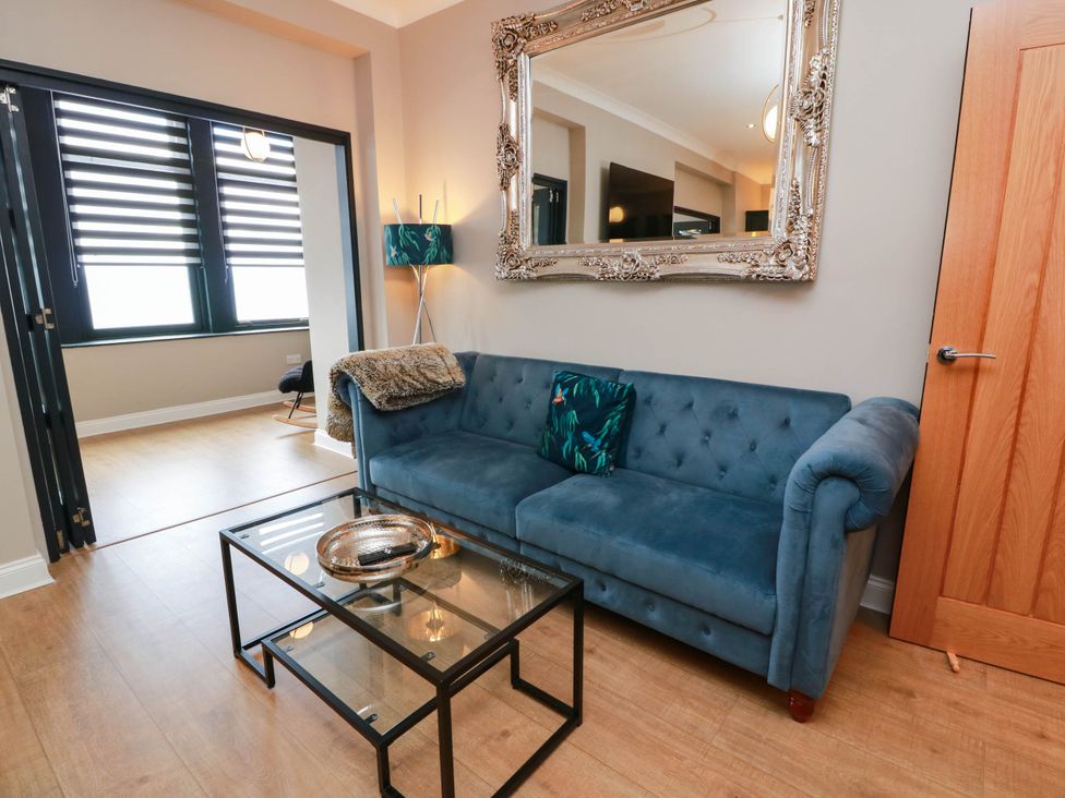 A living room with a sofa and mirror at Flat 1 86 Gallowgate Street in Largs