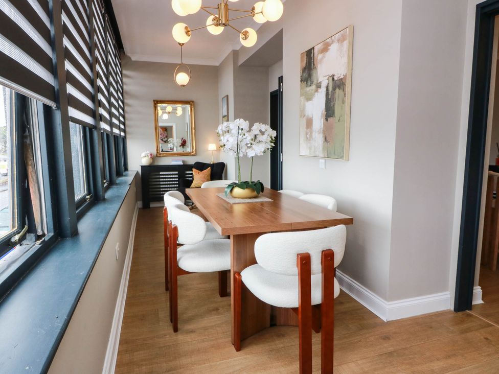 A dining room with a wooden table and chairs at Flat 1 86 Gallowgate Street in Largs