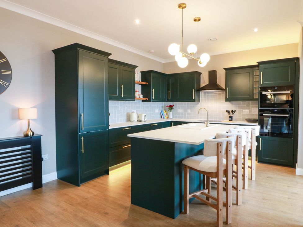 A kitchen with an island and stools at Flat 1 86 Gallowgate Street Largs