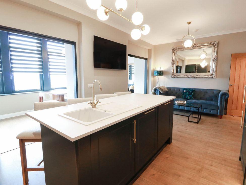 A kitchen with an island and seating at Flat 1 86 Gallowgate Street Largs