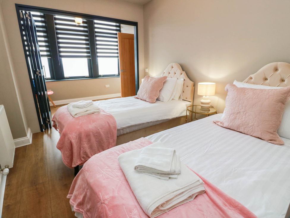 A bedroom with two beds and a lamp at Flat 1 86 Gallowgate Street in Largs
