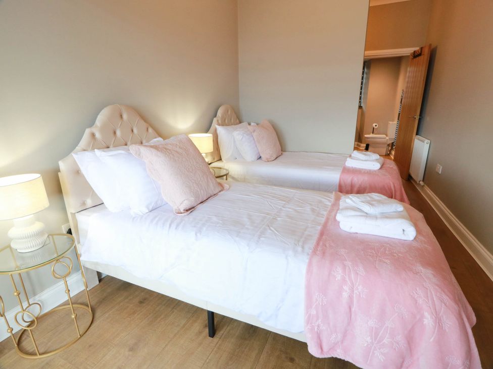 A bedroom with two beds and a lamp at Flat 1 86 Gallowgate Street Largs