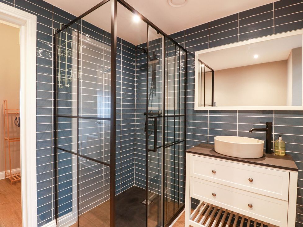 A bathroom with a shower, sink, and mirror at Flat 1 86 Gallowgate Street in Largs