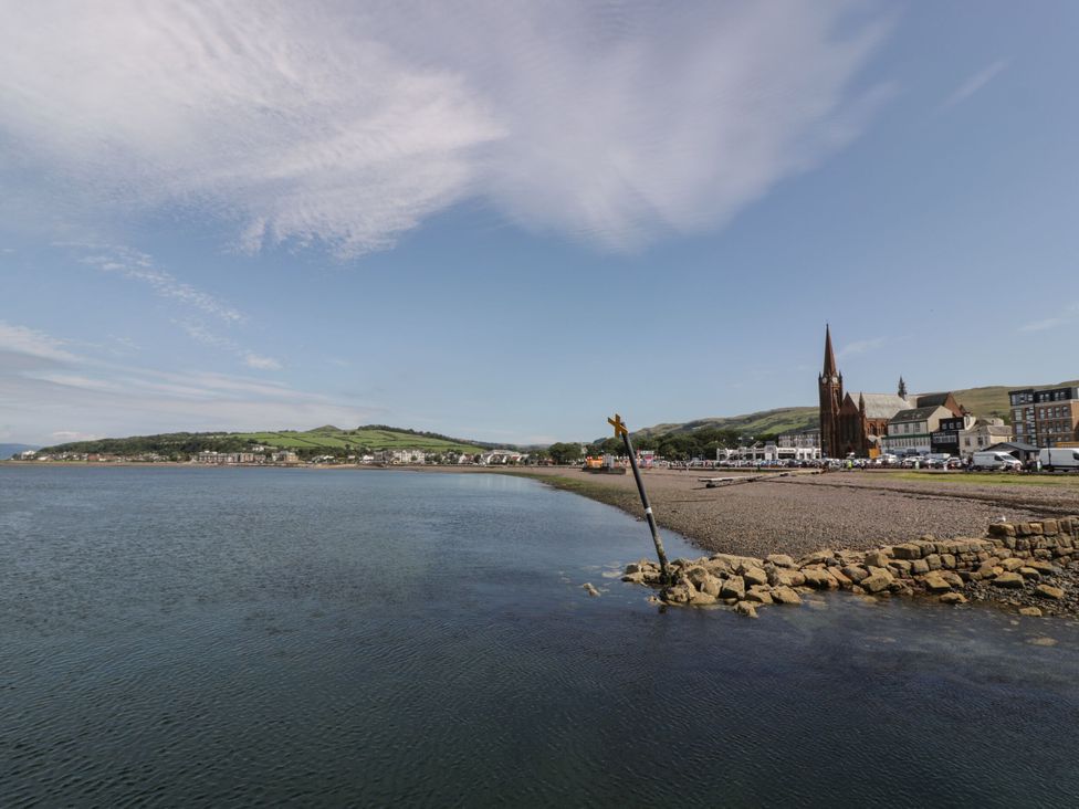 A view of the shoreline with buildings and a church at Flat 1 86 Gallowgate Street Largs