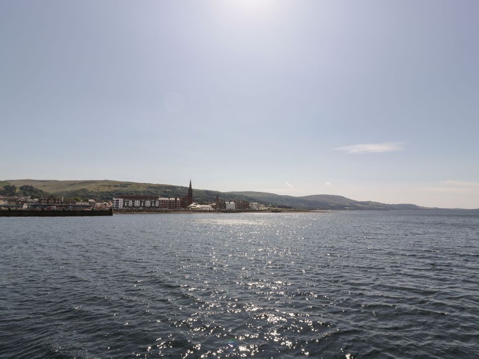 A view of water with buildings and mountains at Flat 1 86 Gallowgate Street Largs