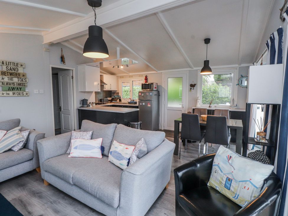 A living room with a sofa and dining area at Lodge 134 Lon Bryn Mair near Bellech