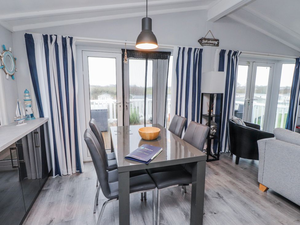A dining room with a table and chairs at Lodge 134 Lon Bryn Mair near Bellech