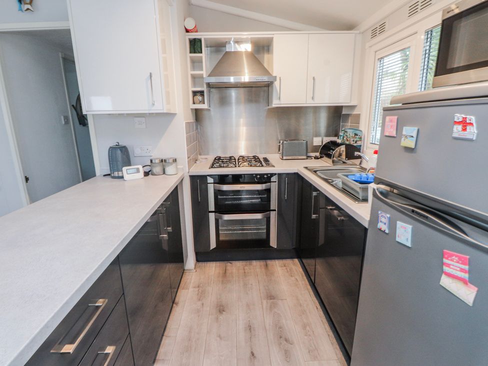 A kitchen with appliances and a countertop at Lodge 134 Lon Bryn Mair near Bellech
