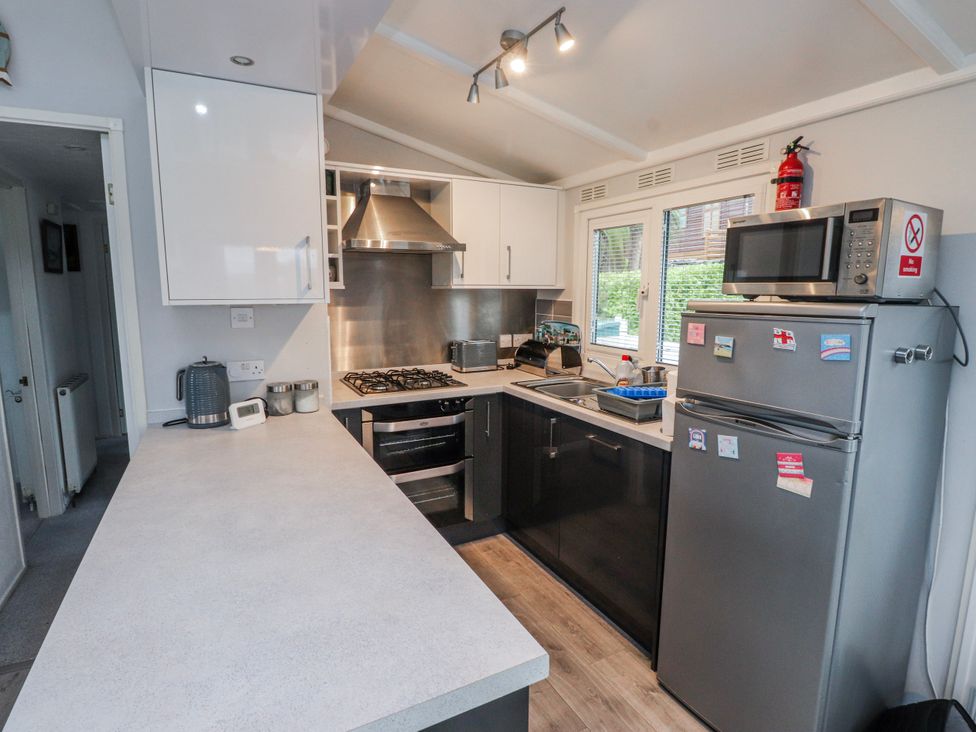 A kitchen with appliances and counter space at Lodge 134 in Lon Bryn Mair near Bellech