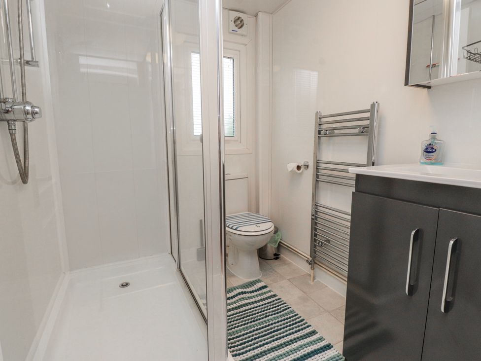 A bathroom with a shower and toilet at Lodge 134 Lon Bryn Mair near Bellech