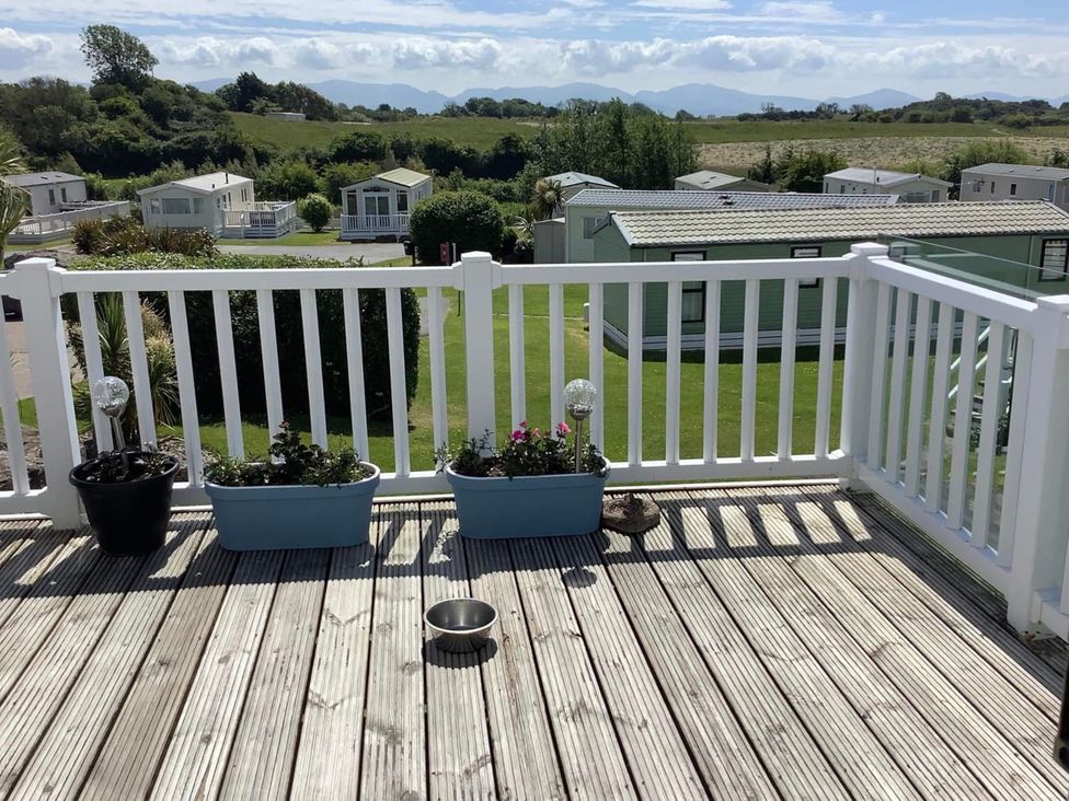 A deck area with planters and a pet bowl at Mynydd View Anglesey
