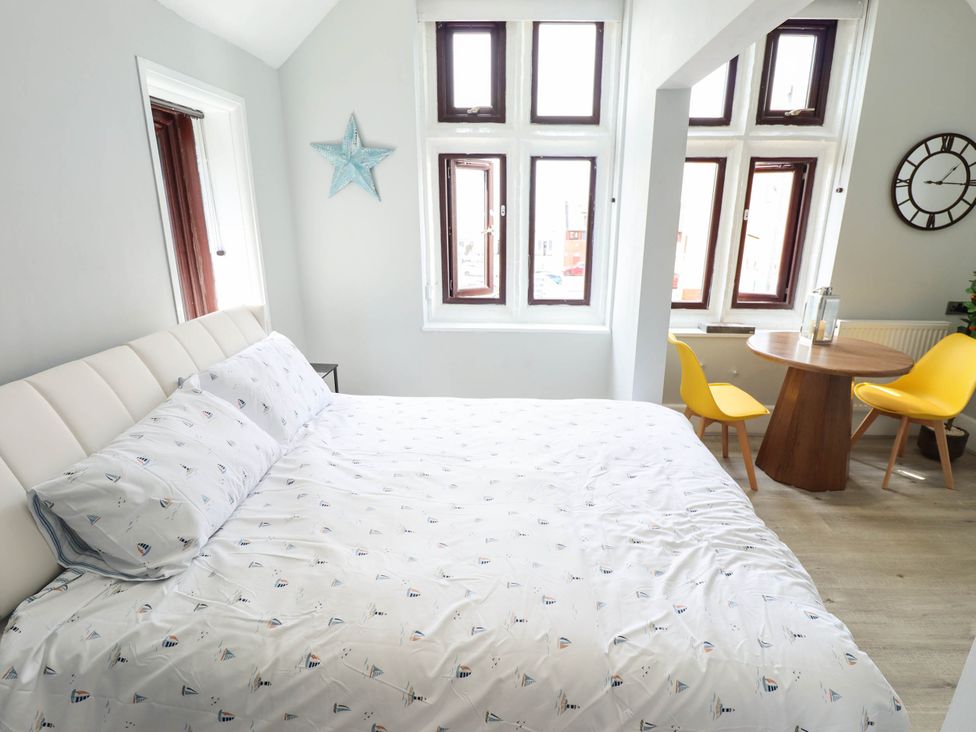 A bedroom with a bed and dining table at The Ocean House   --- Sea Whisper (Top Floor )  Le Strange Terrace Hunstanton