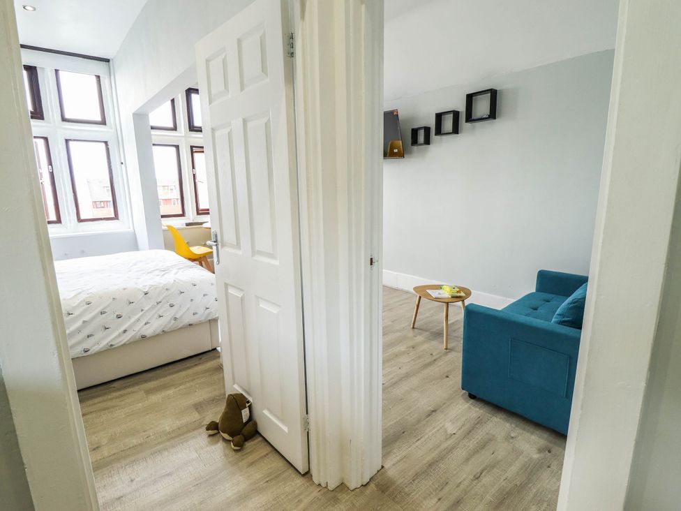 A bedroom with a bed and a sofa at The Ocean House   --- Sea Whisper (Top Floor )  Le Strange Terrace, Hunstanton