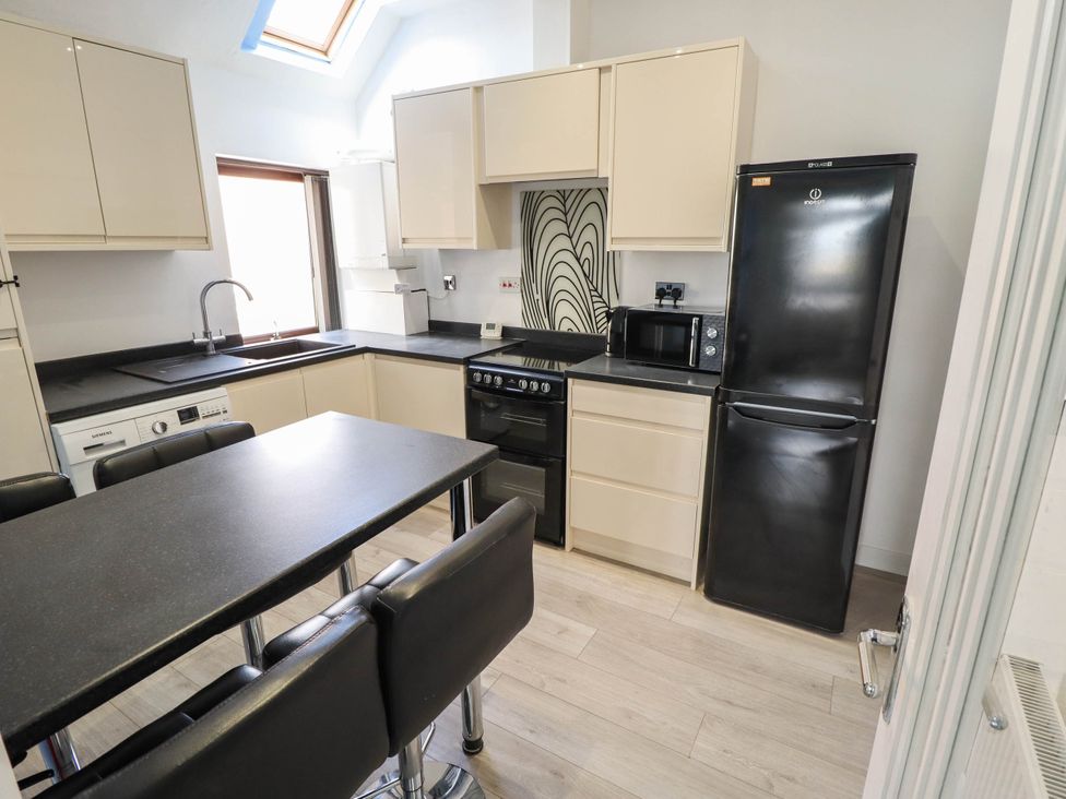 A kitchen with appliances and a table at The Ocean House   --- Sea Whisper (Top Floor )  Le Strange Terrace in Hunstanton